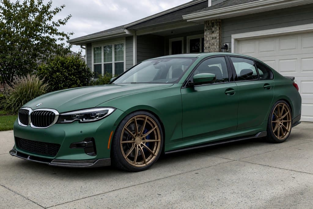 The same BMW from the same photo, customized with bronze forged wheels, a satin green wrap, a lowered stance, and carbon aero